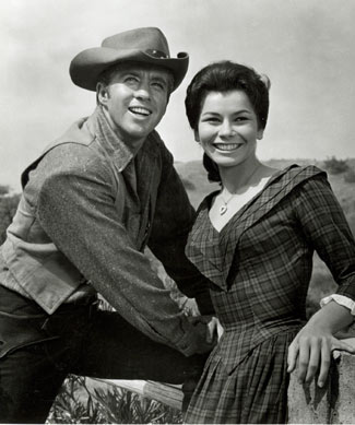 Clu Gulager as Deputy Ryker and Diane Roter as Jennifer take a break from filming "The Virginian" during the '65-'66 season.