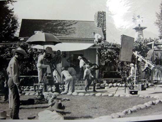 Hopalong Cassidy (William Boyd) stands in the doorway of the Wofford Ranch house at Kernville, CA, as the crew prepares for a shot. This may be from Hoppys “The Showdown” as it was partially filmed on the Wofford Ranch. (Thanx to Bobby Copeland for the photo and Tinsley Yarbrough for the location ID.)