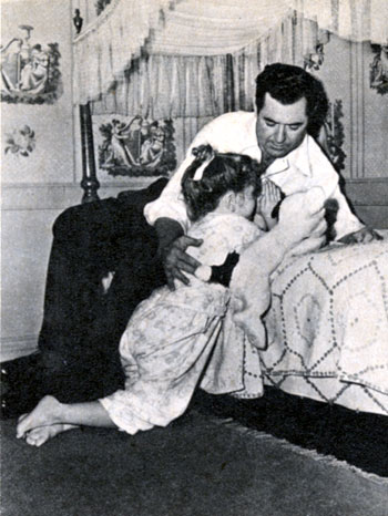 Four year old Cynthia Brown says her prayers with her Dad, Johnny Mack Brown, circa April ‘43.