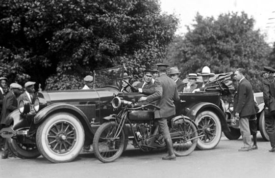 Cars of the Stars: A crowd gathers as Tom Mix is stopped for speeding in 1925. (Thanx to Bobby Copeland.)