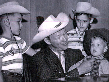 Roy Rogers helps a young fan cinch up his hat string. (Thanx to Colin Jellicoe.)