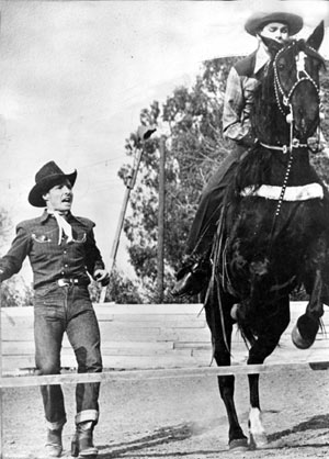 At his Heaven on Earth Ranch, Johnny Carpenter helps blind Jimmie Pruett over the jump on horseback. This builds great moral for handicapped kids.
