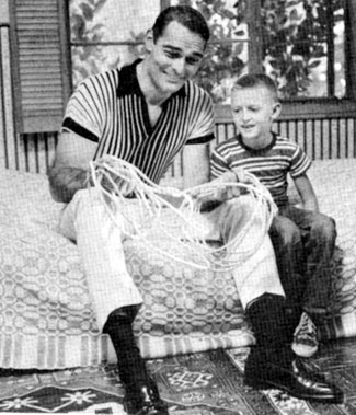At home, John (“Lawman”) Russell shows son John James, age 7, some rope tricks.