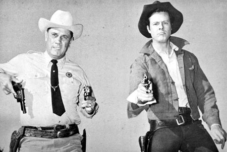 Renowned Texas Ranger Jay Banks teaches Robert Culp how to “thumb that hammer” for Culp’s role as Ranger Hoby Gilman on “Trackdown”. Banks later became Chief of Police in Palestine, Texas.