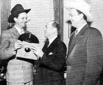 Bill (Cowboy Rambler) Boyd watches as his brother Jim presents an official recording of “Palace in Dallas” to Mayor Rogers of Dallas, TX, sometime in the late ‘40s.