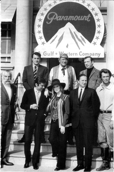 Paramount executives pose with stars that were making productions on the studio lot in 1969. (Front row, l-r) Lee Marvin (“Paint Your Wagon”), Paramount VP Robert Evans, Barbra Streisand (“On a Clear Day You Can See Forever”), Paramount VP Bernard Donnenfeld, Clint Eastwood (“Paint Your Wagon”). (Top row, l-r) Rock Hudson (“Darling Lili”), John Wayne (“True Grit”), Yves Montand (“On a Clear Day You Can See Forever”). (Thanx to Frank Story.)