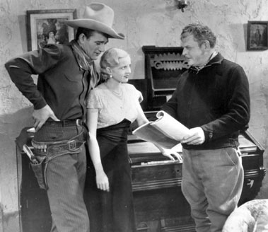 Director Robert North Bradbury goes over a plot point in the script of “Texas Terror” (‘35 Lone Star) with John Wayne and Lucile Browne.