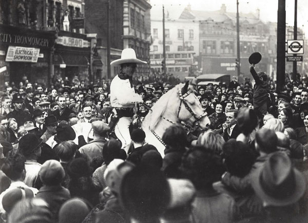Tom Mix thronged by a crowd during his final British tour in 1938. Tom is not riding Tony, but instead his daughter Ruth's horse Warrior which she used in her circus work. Tom elected to use Warrior instead of Tony as Warrior was bigger and could be seen better. (Thanx in part to Bud Norris.)