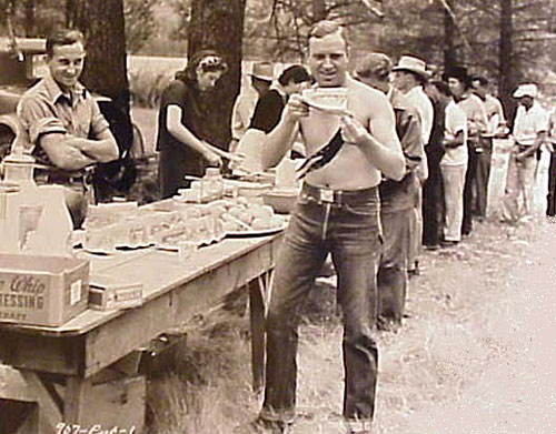 Gene savors a slice of watermelon while on location lunch break. Note Smiley Burnette further back in line. (Thanx to Jerry Whittington.)