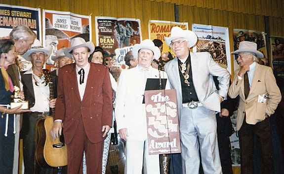 1985 Golden Boot Awards. (L-R) Pam Murphy (Audie’s widow), James Stewart, Eddie Dean, Jerry Scoggins, Pat Buttram, Iron Eyes Cody, Gene Autry, Monte Hale, Richard Farnsworth talks to Dale Robertson behind Monte.