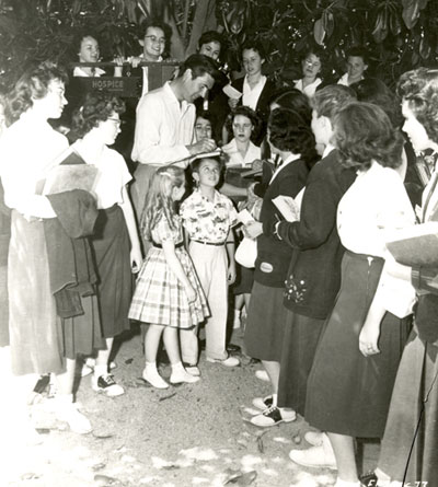 Fess Parker signs autographs for a group of female fans.