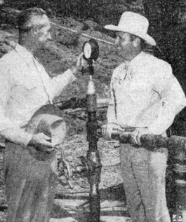 Gene Autry watches the gage on a Wichita Falls oil well with his co-owner S. D. Johnson of Wichita Falls. Circa late ‘40s.