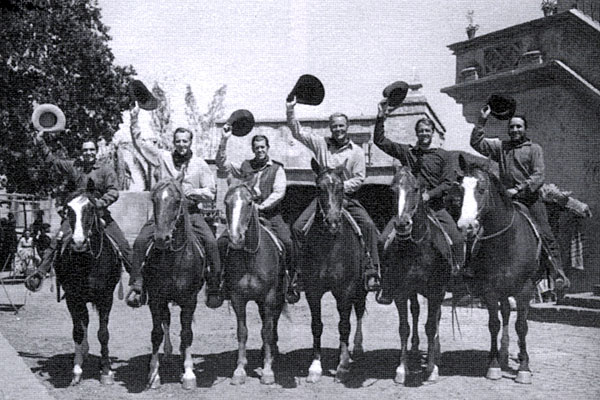 The casts of two Warner Bros. westerns were shooting on adjacent locations when they came together for this photo in 1949. (L-R) Bob Steele, Bruce Bennett, James Brown, Wayne Morris, Joel McCrea, Victor Jory. Steele, McCrea and Jory were working on “South of St. Louis” while Bennett, Brown and Morris were working on “The Younger Brothers”.