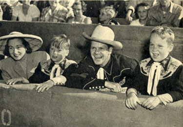 Rodeo fans all, lined up in front row seats...Dan Duryea with wife Helen and sons Peter (left) and Richard.