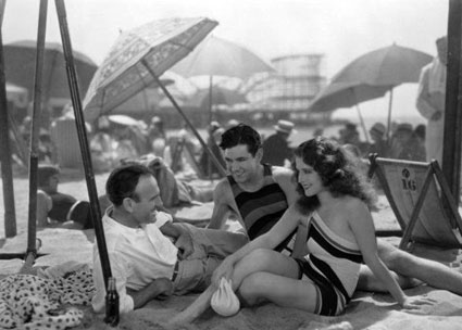 A day at the beach with director Sam Wood, Johnny Mack Brown and Norma Shearer.