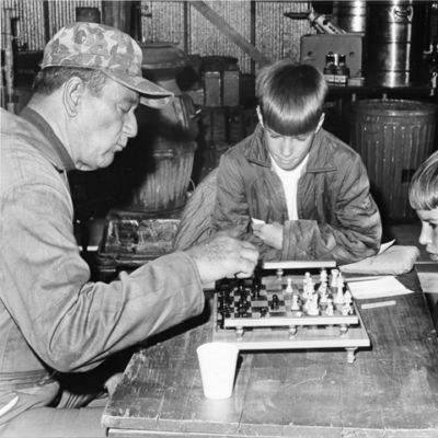 John Wayne teaches some youngsters the art of playing Chess during a break from filming “Hellfighters”. (Thanx to Bobby Copeland.)