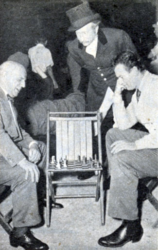 During a break from the making of “Dakota” (‘45), John Wayne (right) matches wits in a game of chess with Republic studio head Herbert J. Yates as character player Olin Howland looks on.