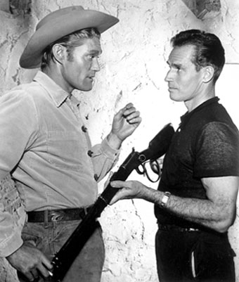 Chuck Connors talks about “the rifle” with Charlton Heston.