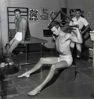 Meanwhile, in another gym, Jock Mahoney takes a break and watches Clint Eastwood work out.