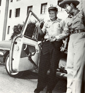 TV’s U.S. Marshal, John Bromfield, admires Tucson policeman Jimmy Adcock’s rifle outside the old Pima County Courthouse.