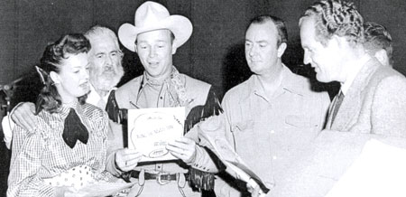 Dale Evans, Gabby Hayes, Roy Rogers and three members of the Riders of the Purple Sage (Al Sloey, Scotty Harrell [face hidden] and Foy Willing) prepare to make a recording of “Along the Navajo Trail” for the weekly Roy Rogers radio program in the late ‘40s.