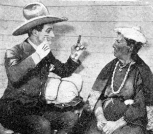 Tom Mix in 1923 explaining to an Indian lady what a razor and shaving is all about.