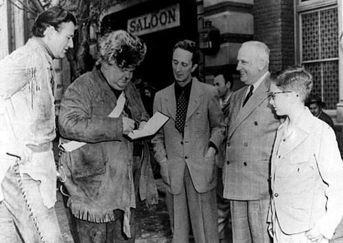 Alongside John Wayne, while making “The Fighting Kentuckian” (‘49), Oliver Hardy signs an autograph for noted artist Norman Rockwell (center).