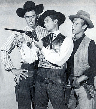 Hugh “Wyatt Earp” O'Brian shows off his Buntline Special to Clint “Cheyenne” Walker and John Lupton of “Broken Arrow”.