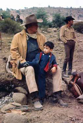 John Wayne with three-year old son Ethan on location for “The Sons of Katie Elder” (‘65). Costar Dean Martin looks off in the distance.