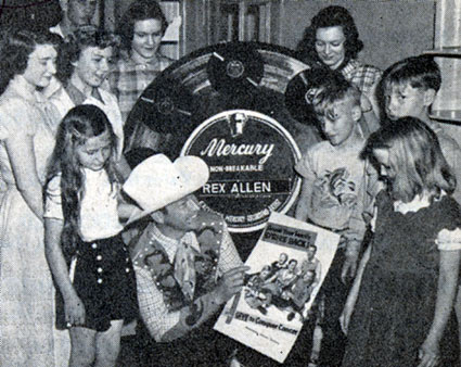 Republic's Rex Allen poses in June 1951 with a group of children against the backdrop of an enlarged Mercury Record (his label) during a cross country tour for the Cancer Drive. 