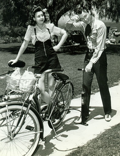 Roy Rogers tries to help Jane Withers with a flat bicycle tire.
