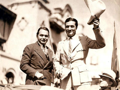 Screen gangster Edward G. Robinson and screen cowboy Tom Mix greet the public. Circa late ‘30s.