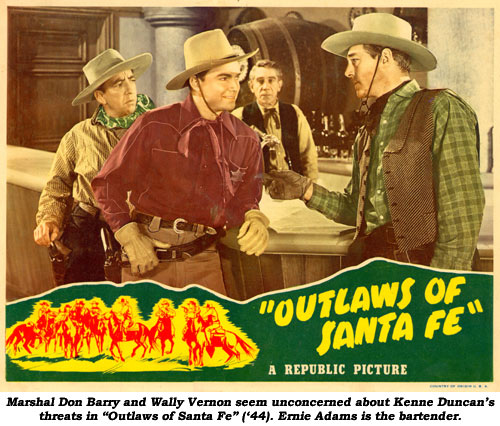 Marshal Don Barry and Wally Vernon seem unconcerned about Kenne Duncan's threats in "Outlaws of Santa Fe" ('44). Ernie Adams is the bartender.